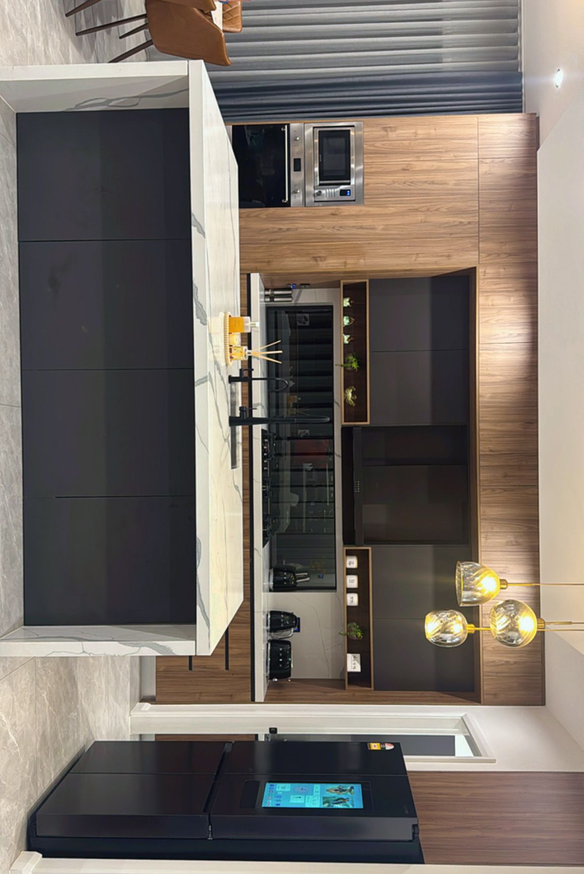 Modern kitchen with black cabinetry, timber wall panelling, marble-look island benchtop and built-in appliances