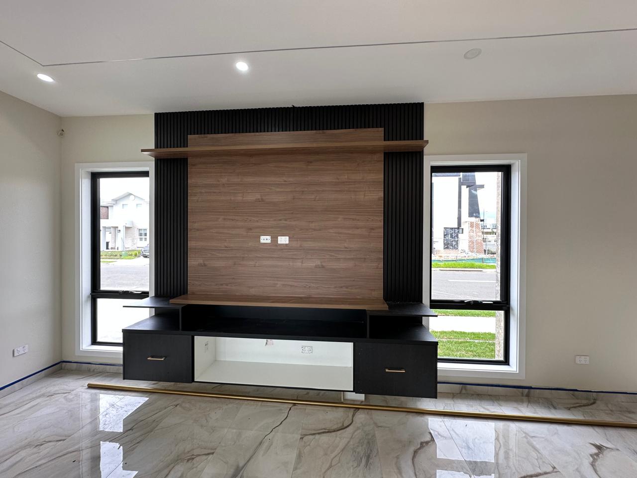 Custom timber TV entertainment unit with black cabinetry and floating display shelf