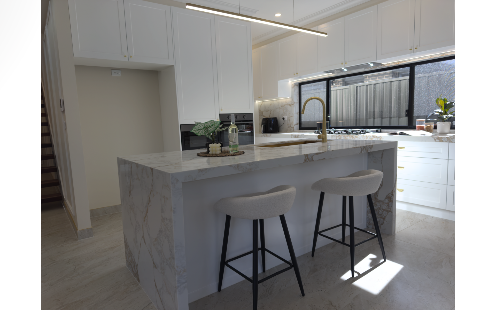 Modern kitchen with wood-grain cabinetry, white quartz countertops, large island and pendant lighting