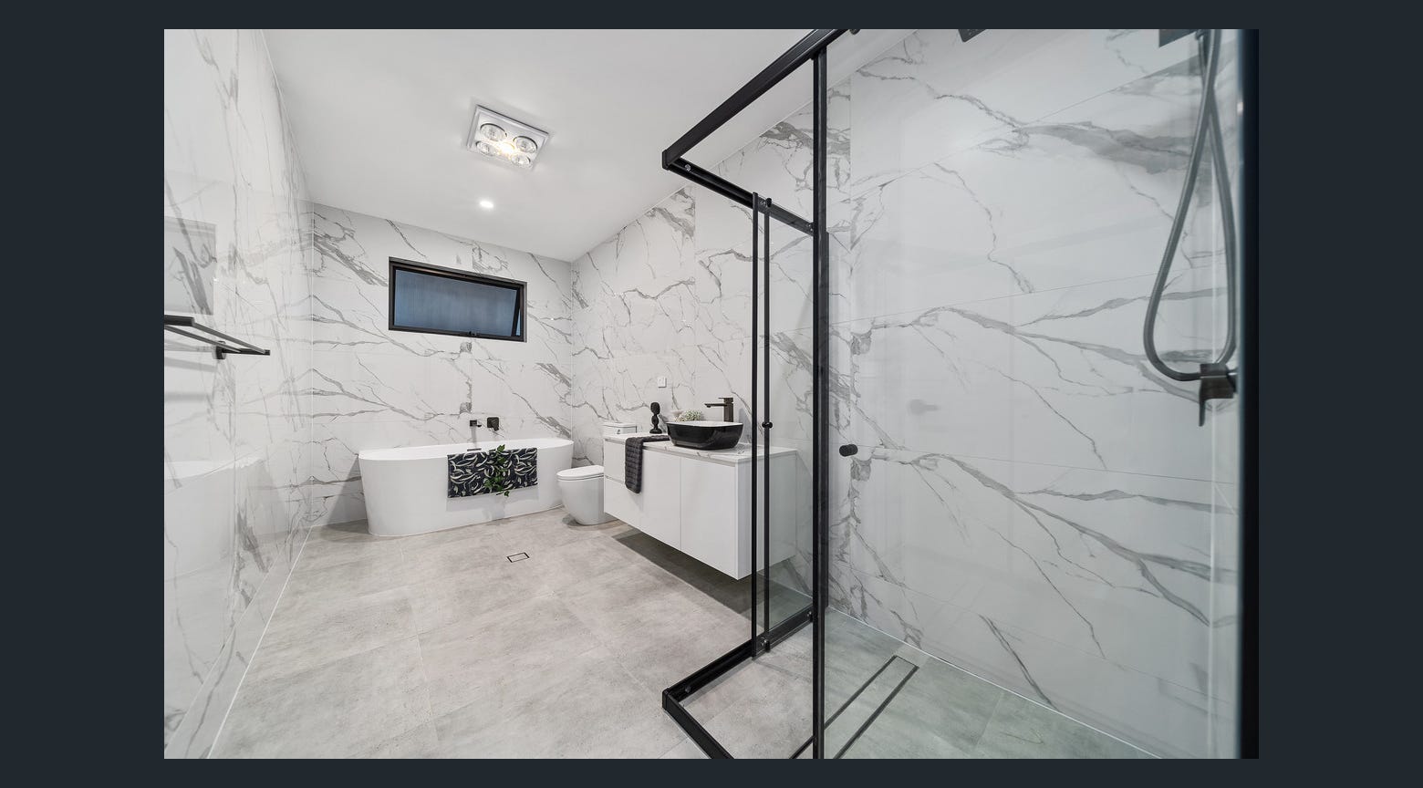 Luxury bathroom with freestanding bathtub, custom white vanity and black-framed glass shower