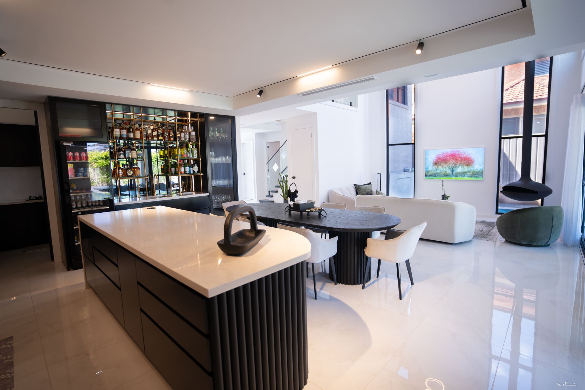 Luxury open-plan kitchen with custom island, dining area and built-in display cabinetry