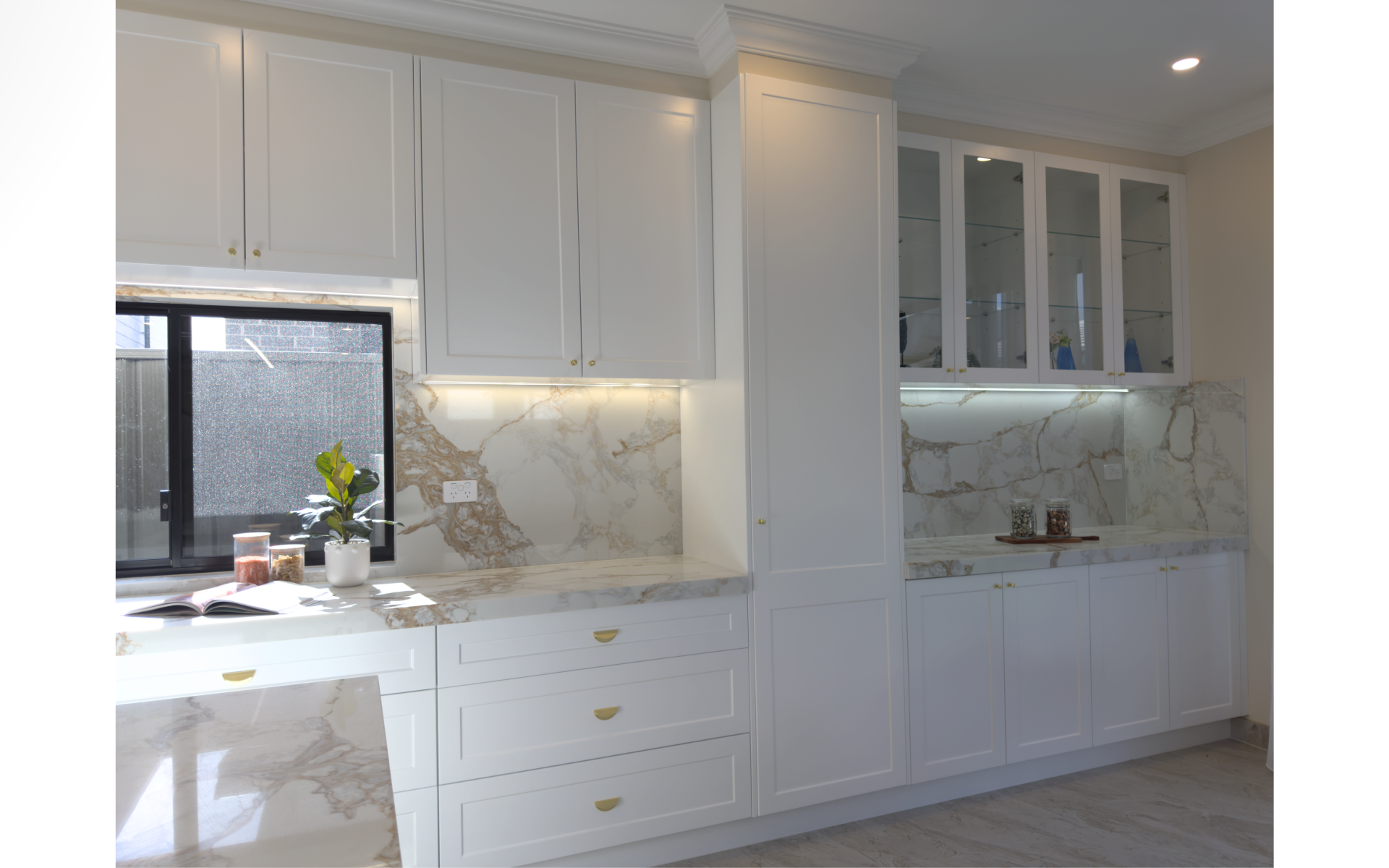 Contemporary kitchen with wood-grain cabinets, white quartz island, black refrigerator and integrated storage