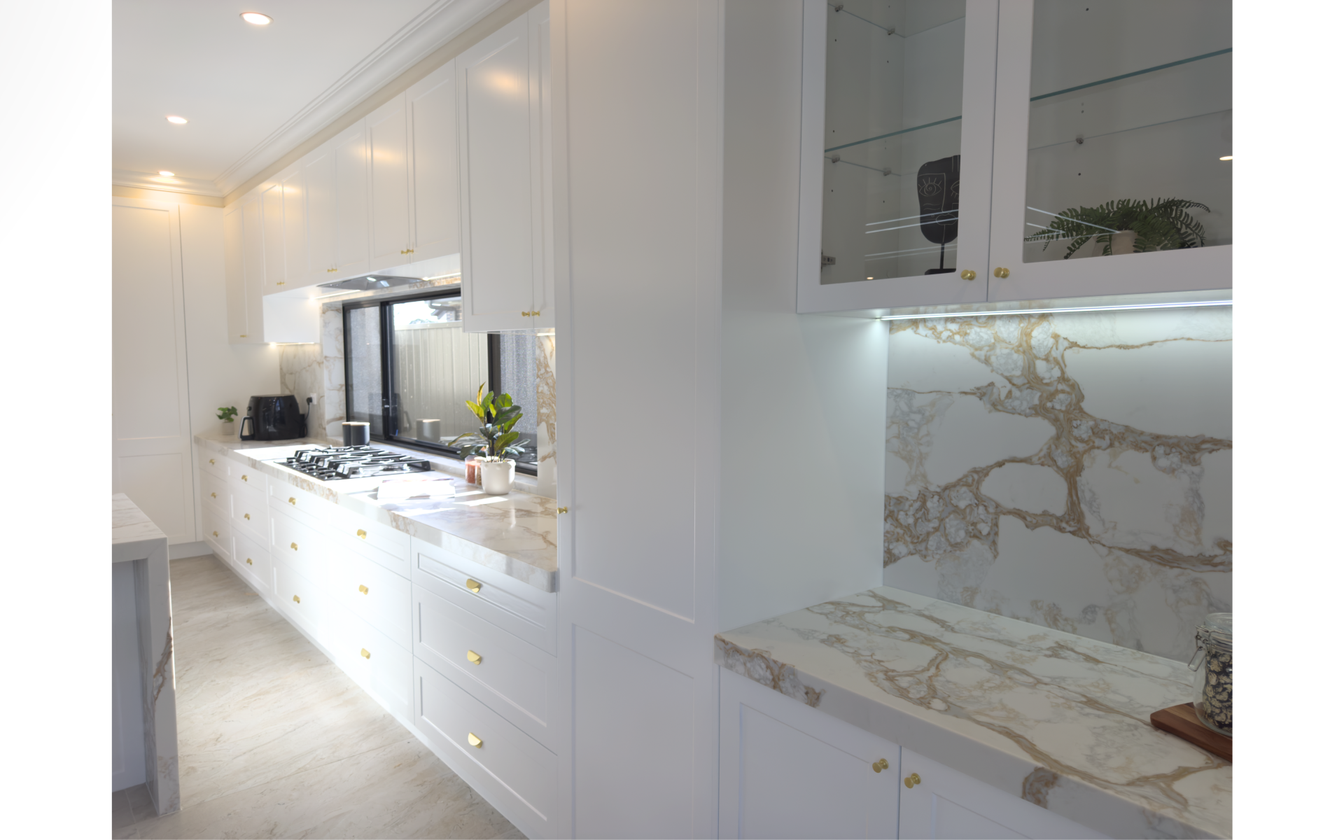 Modern kitchen featuring wood-grain cabinetry, white quartz countertops, gas cooktop and built-in oven