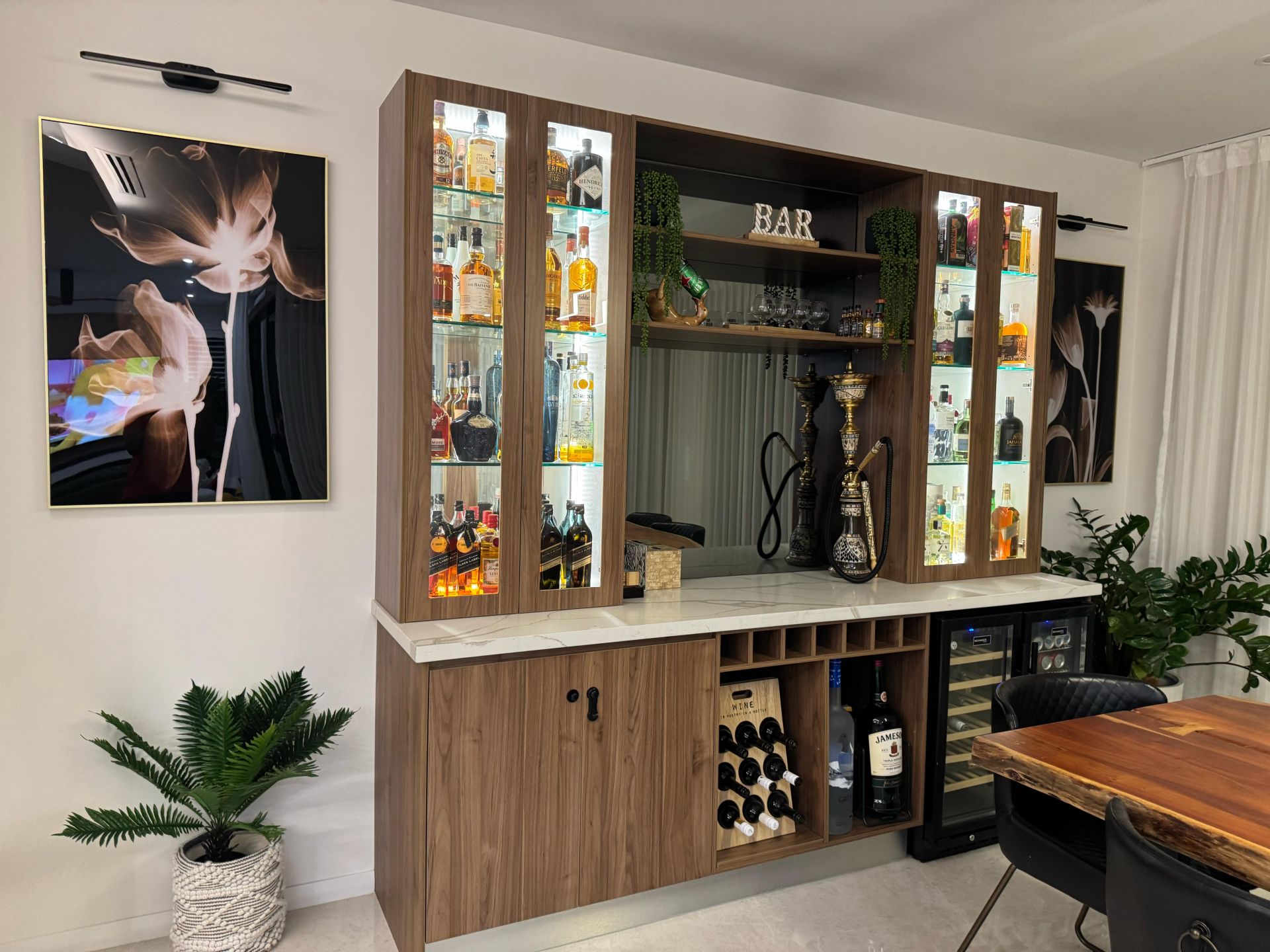 Custom home bar with illuminated glass cabinets, wood cabinetry, wine storage and display shelving