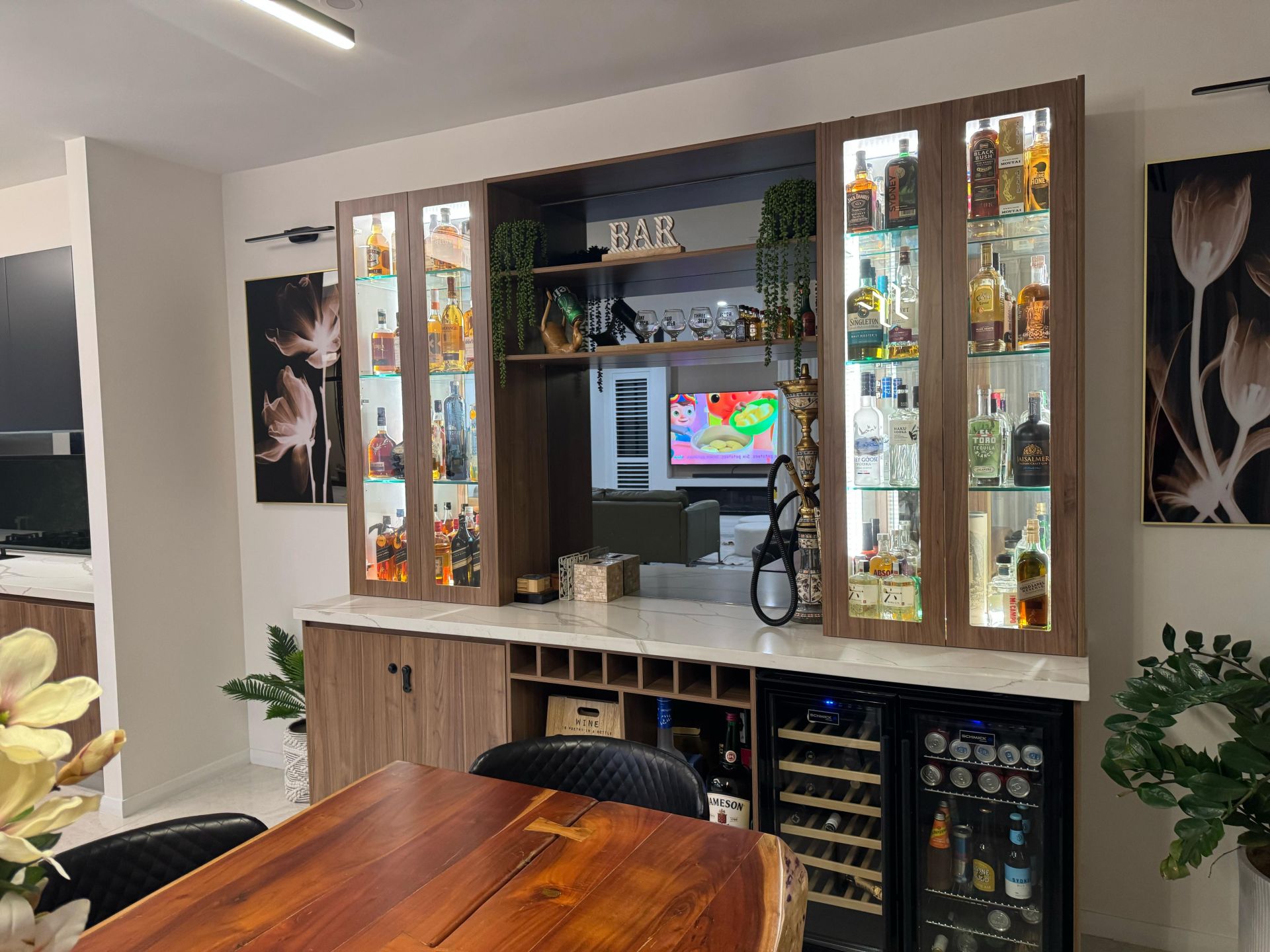 Custom home bar with illuminated liquor display cabinets, wine storage, glassware shelving and wood cabinetry