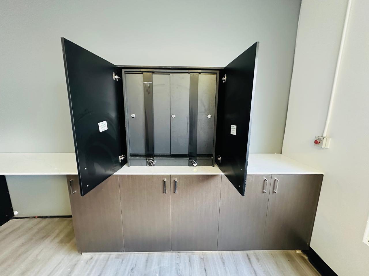 Built-in office cabinetry with open cupboard doors revealing internal storage compartments