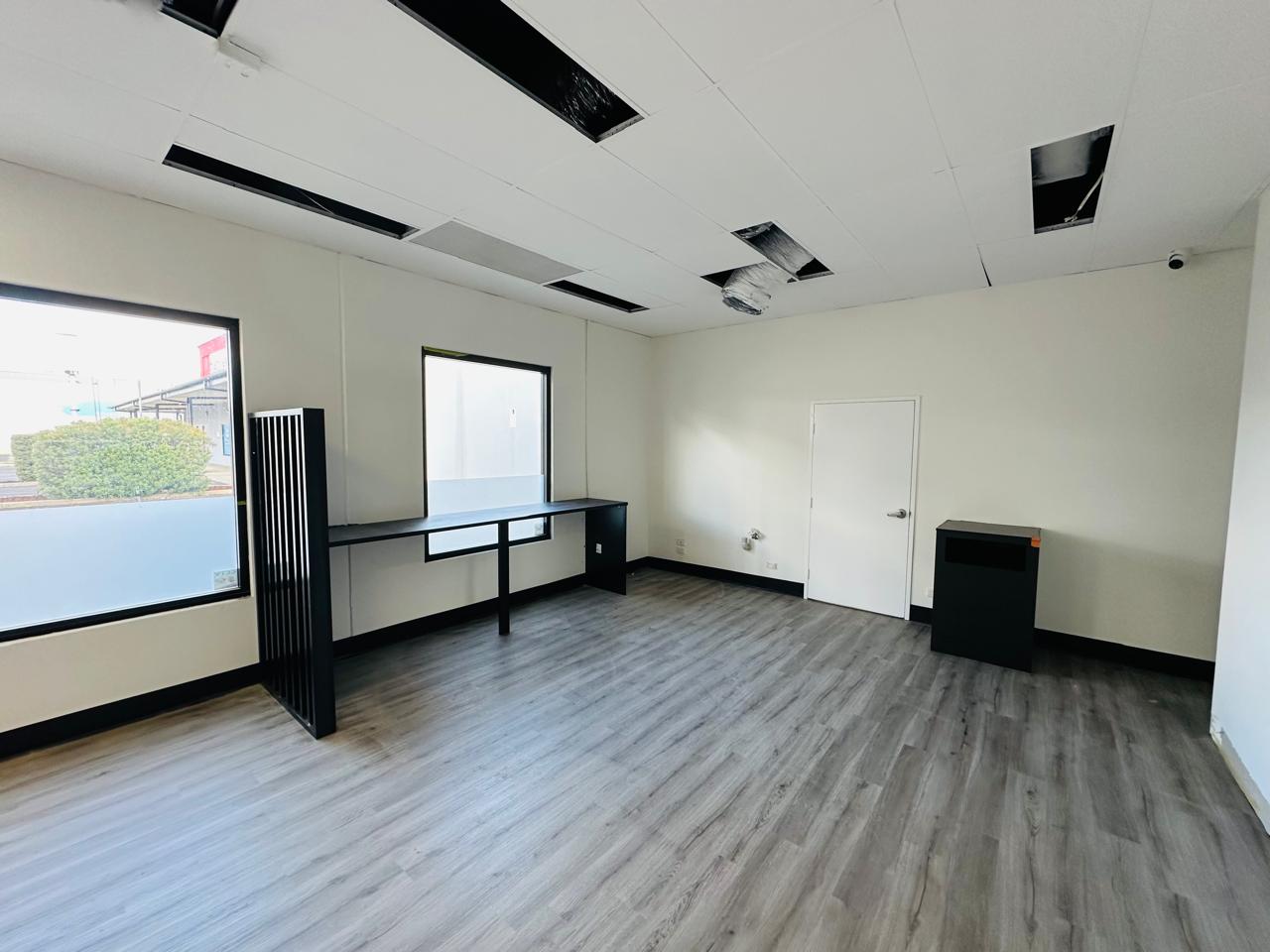 Modern commercial office interior with custom black desk, partition and storage cabinet