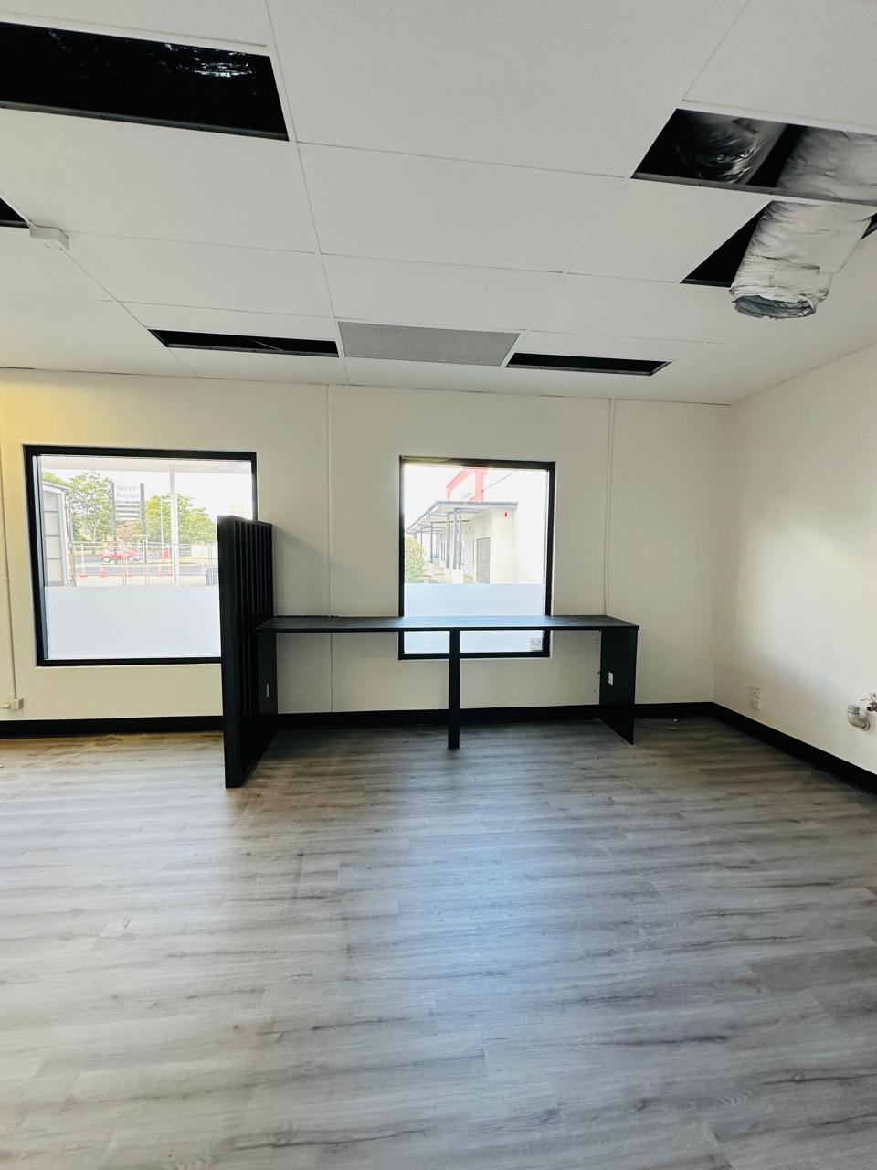 Built-in black office desk with partition screen and large windows
