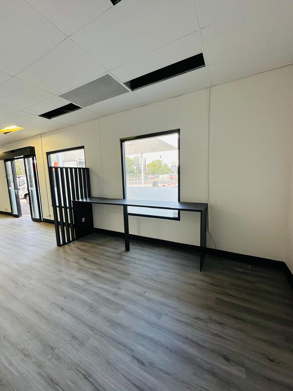 Custom office workstation with black benchtop, partition screen and window opening