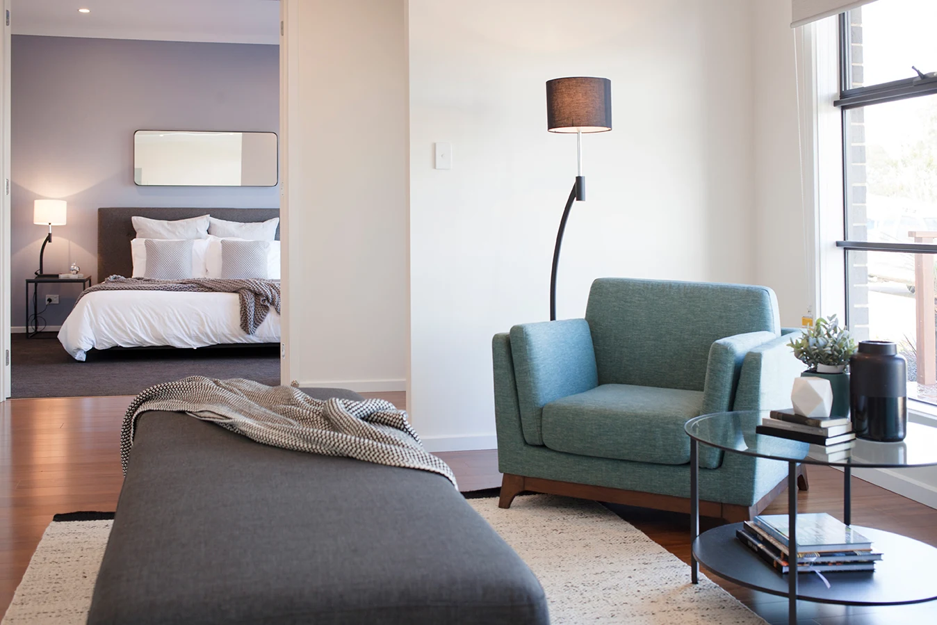 Modern bedroom with upholstered bed, lounge chair, bedside table and built-in interior finishes