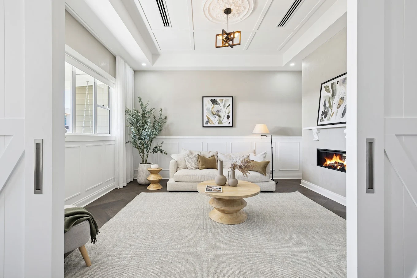 Elegant living room with white built-in wall panelling, fireplace and custom interior finishes