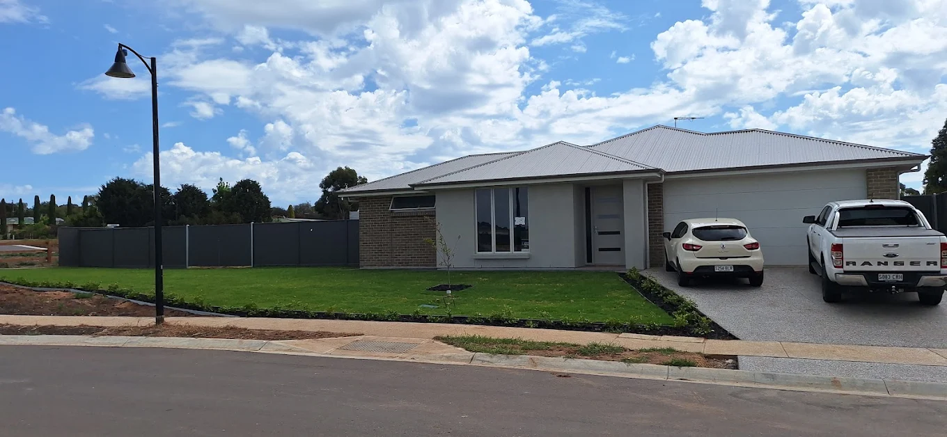 Single-storey modern home exterior with double garage, front lawn and driveway
