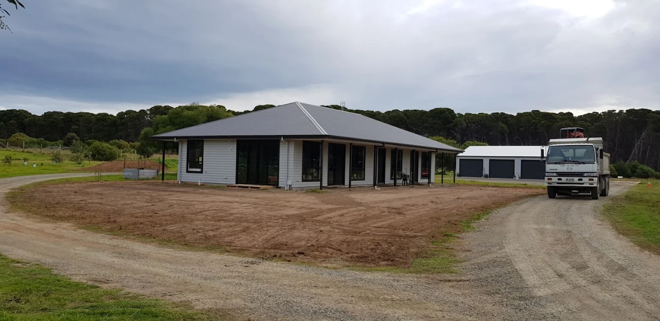 Single-storey home under construction on a large rural property with detached garage and construction truck