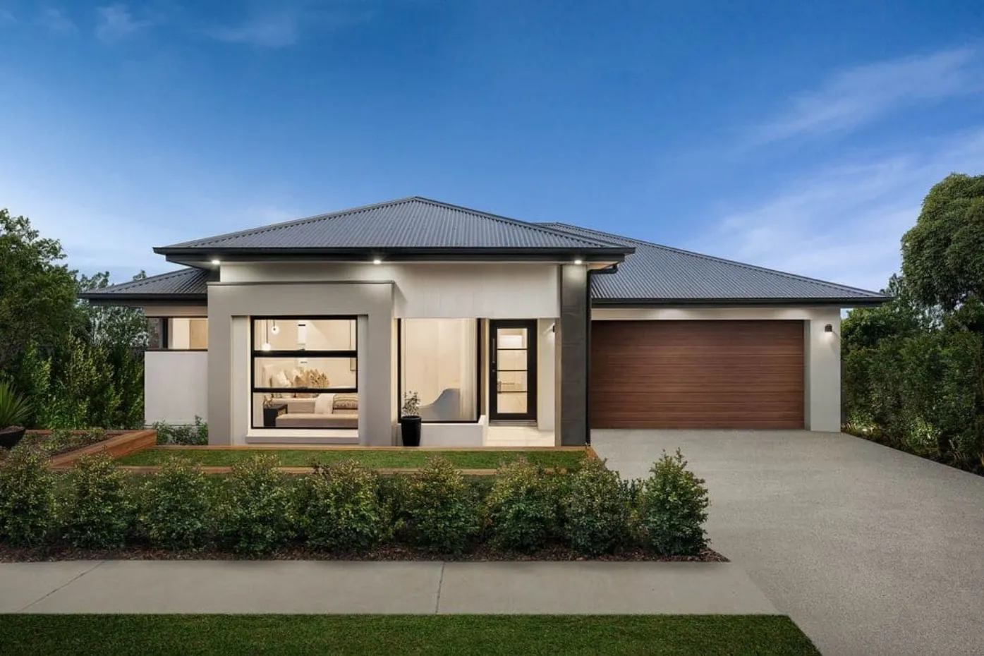 Modern single-storey home with white exterior, dark grey roof, timber garage door and landscaped front yard